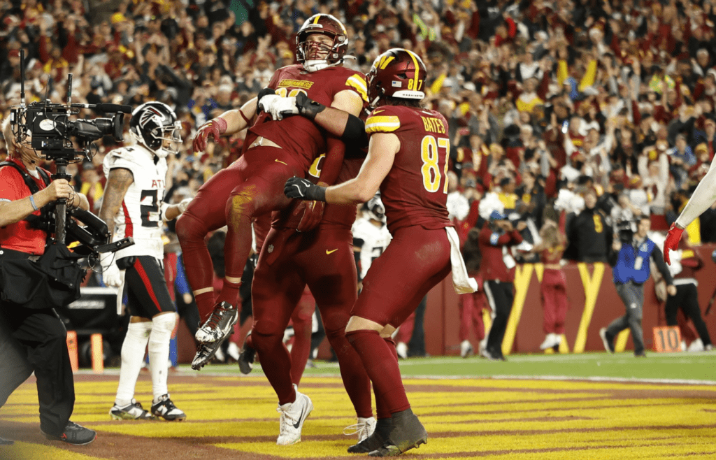 Dec 29, 2024; Landover, Maryland, USA; Washington Commanders tight end Zach Ertz (86) celebrates with teammates after scoring the game-winning touchdown against the Atlanta Falcons in overtime at Northwest Stadium. Mandatory Credit: Geoff Burke-Imagn Images