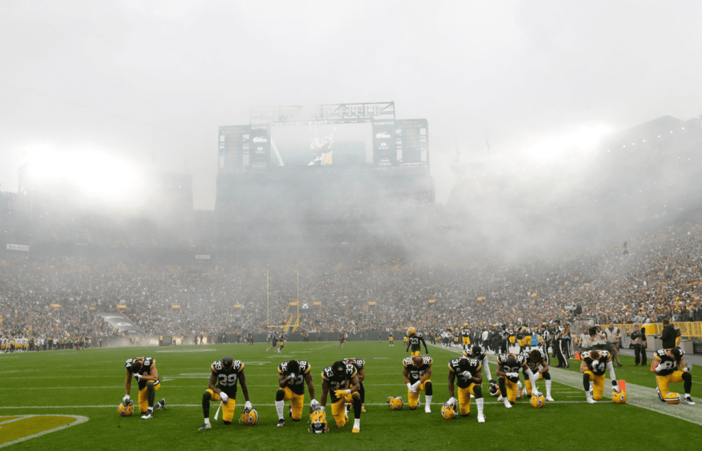 Green Bay Packers players take a knee befor playing against the Pittsburgh Steelers during their football game, at Lambeau Field in Green Bay, Wisconsin