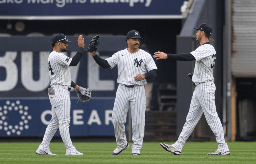 May 22, 2025; Bronx, New York, USA; New York Yankees left fielder Jasson Dominguez (24) celebrates with center fielder Trent Grisham (12) and right fielder Cody Bellinger (35) after defeating the Texas Rangers at Yankee Stadium. Mandatory Credit: Vincent Carchietta-Imagn Images