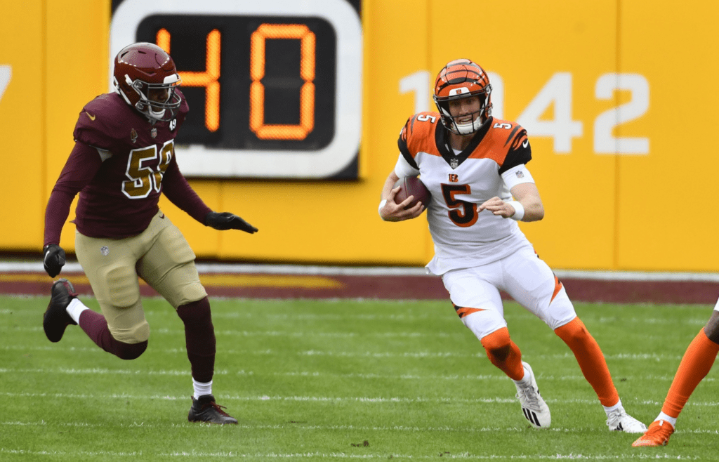 Nov 22, 2020; Landover, Maryland, USA; Cincinnati Bengals quarterback Ryan Finley (5) carries the ball against Washington Football Team outside linebacker Thomas Davis (58) during the second half at FedExField. Mandatory Credit: Brad Mills-Imagn Images