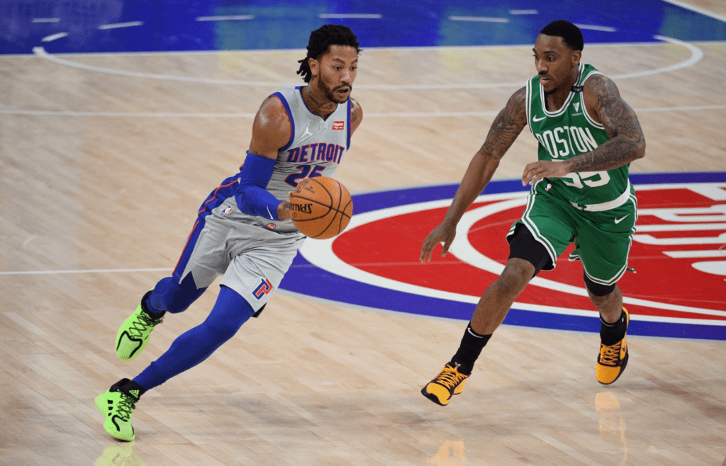 Jan 1, 2021; Detroit, Michigan, USA; Detroit Pistons guard Derrick Rose (25) drives past Boston Celtics guard Jeff Teague (55) during the first quarter at Little Caesars Arena. Mandatory Credit: Tim Fuller-Imagn Images