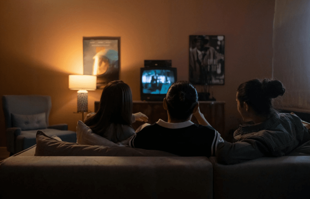Friends watching TV and shouting at each other jokingly