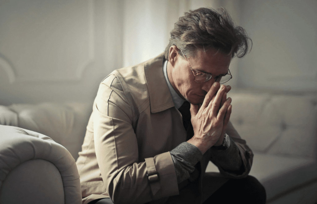 A person sitting alone, looking unsure or upset
