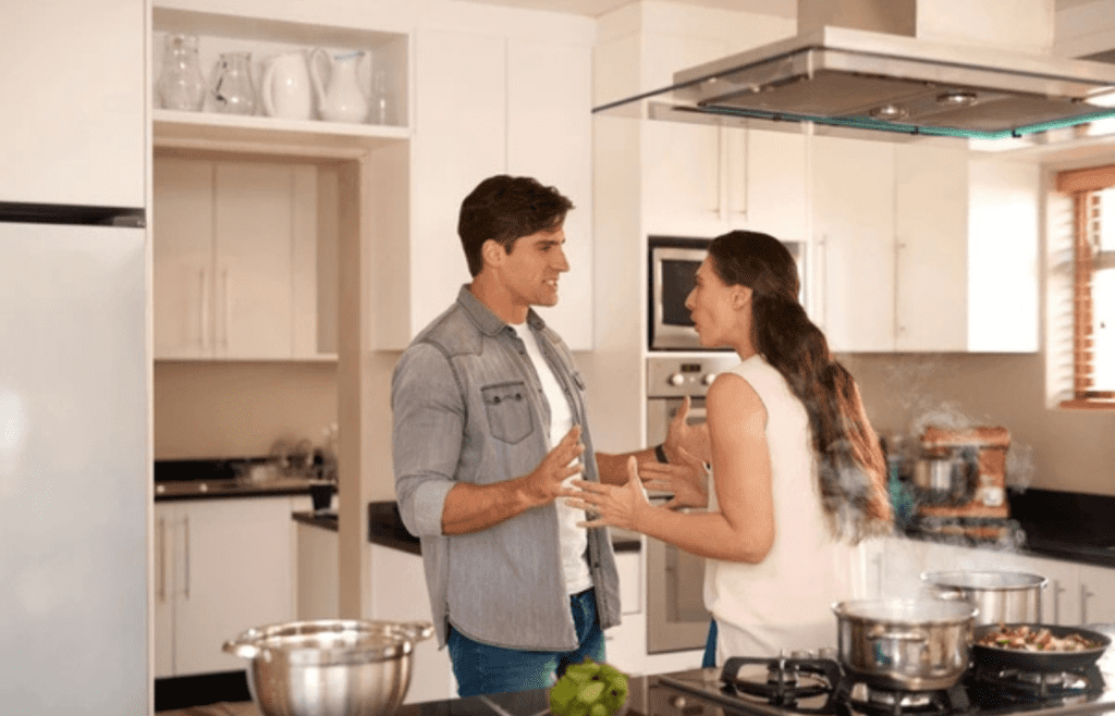 Two people arguing in a kitchen or living room