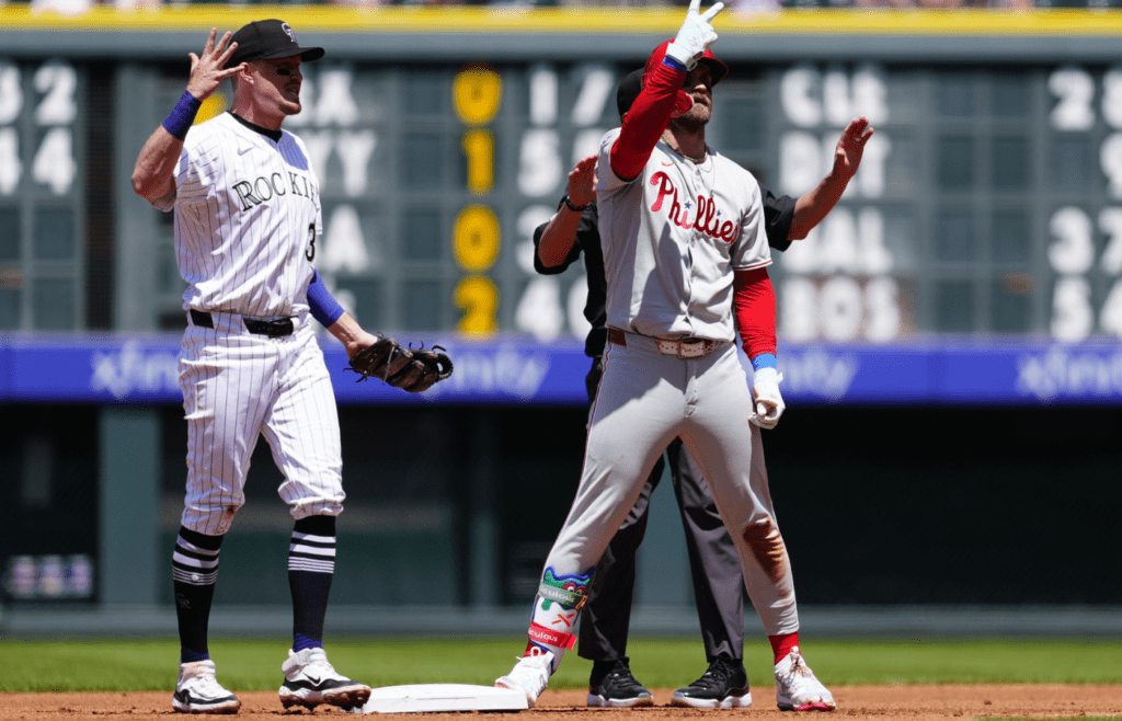 May 22, 2025; Denver, Colorado, USA; Philadelphia Phillies first baseman Bryce Harper (3) celebrates his RBI double next to Colorado Rockies shortstop Aaron Schunk (30) at Coors Field. Mandatory Credit: Ron Chenoy-Imagn Images