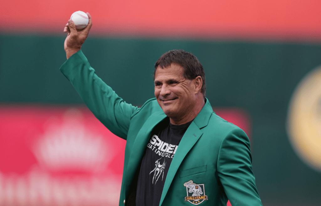 Aug 17, 2024; Oakland, California, USA; Oakland Athletics former outfielder Jose Canseco prepares to throw the ceremonial first pitch before the game against the San Francisco Giants at Oakland-Alameda County Coliseum. Mandatory Credit: Darren Yamashita-Imagn Images