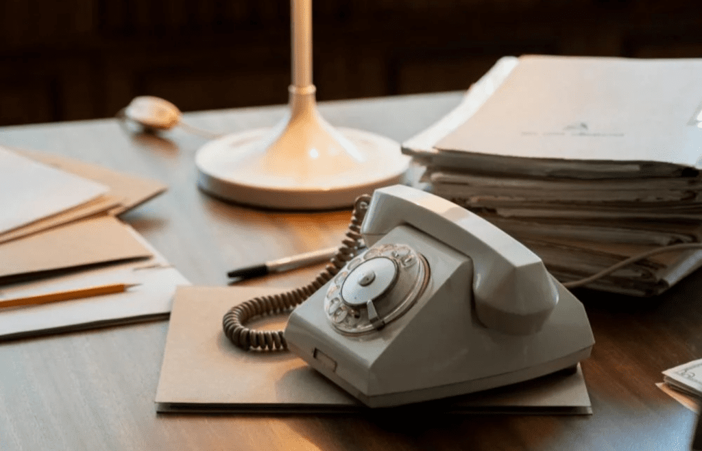 A rotary dial telephone on a desk