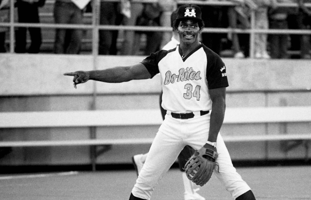 Chicago Bears star running back Walter Payton, a member of Barbara Mandrell's Do-Rites team, points out something to a teammate during warm ups before the start of the Celebrity Softball Classic at Vanderbilt Stadium on May 28, 1984.