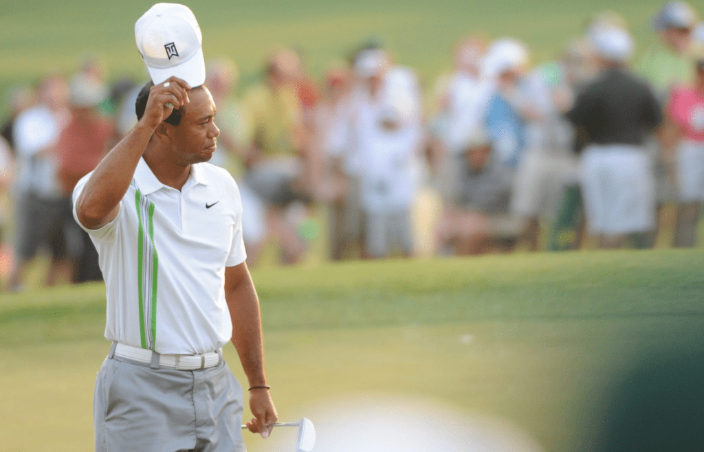 Tiger Woods tips his hat to the gallery after his birdie putt to go to 7-under par for the tournament during the second round of the 75th Masters on April 8, 2011