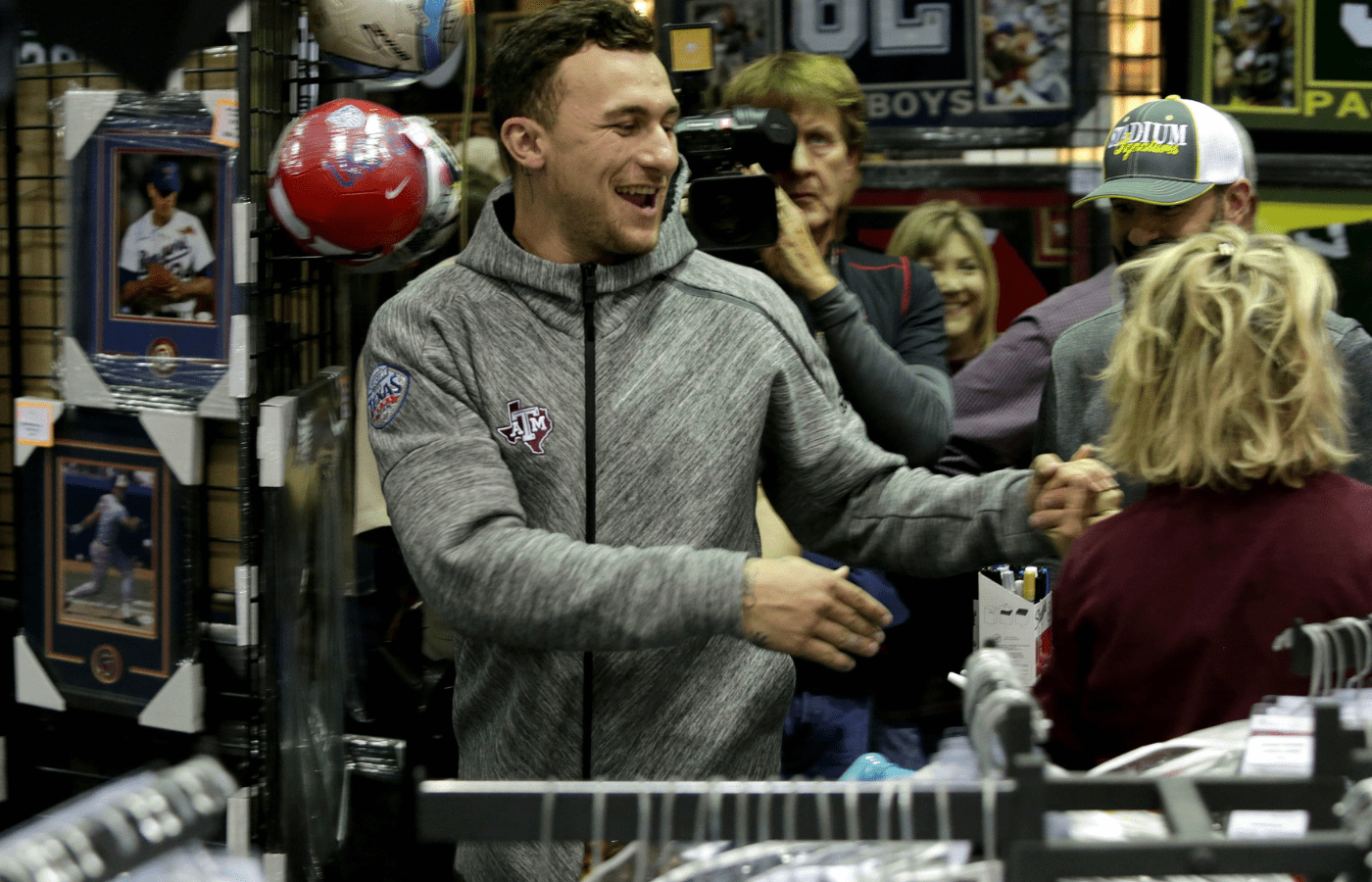 Feb 2, 2017; Katy, TX, USA; Sherry Collins, of Waco, Texas and former Texas A&M quarterback and 2012 Heisman Trophy winner Johnny Manziel have fun talking with each other as Manziel walked out for a portrait session inside Stadium Signatures inside the Katy Mills Mall. Collins was first in line and waited 3 hours to get a picture taken with Manziel and an autograph. Hundreds of Texas A&M fans and alumni paid $99 to have their picture taken with Manziel or the $99 allowed them to get one item autographed by Manziel who is still loved in the state of Texas for many. Mandatory Credit: Eric Seals-Imagn Images