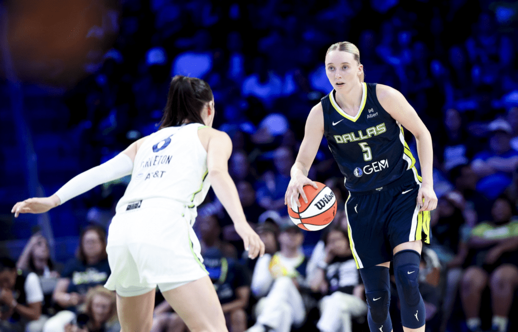 May 16, 2025; Arlington, Texas, USA; Dallas Wings guard Paige Bueckers (5) dribbles as Minnesota Lynx forward Bridget Carleton (6) defends during the second half at College Park Center. Mandatory Credit: Kevin Jairaj-Imagn Images