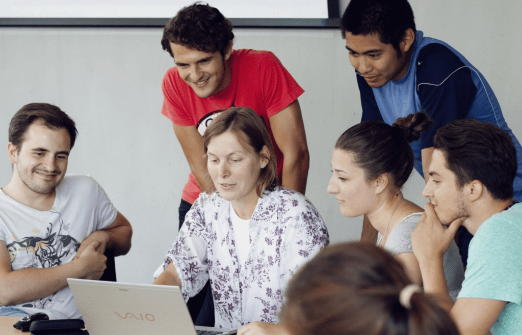 A person lecturing while others glance at each other