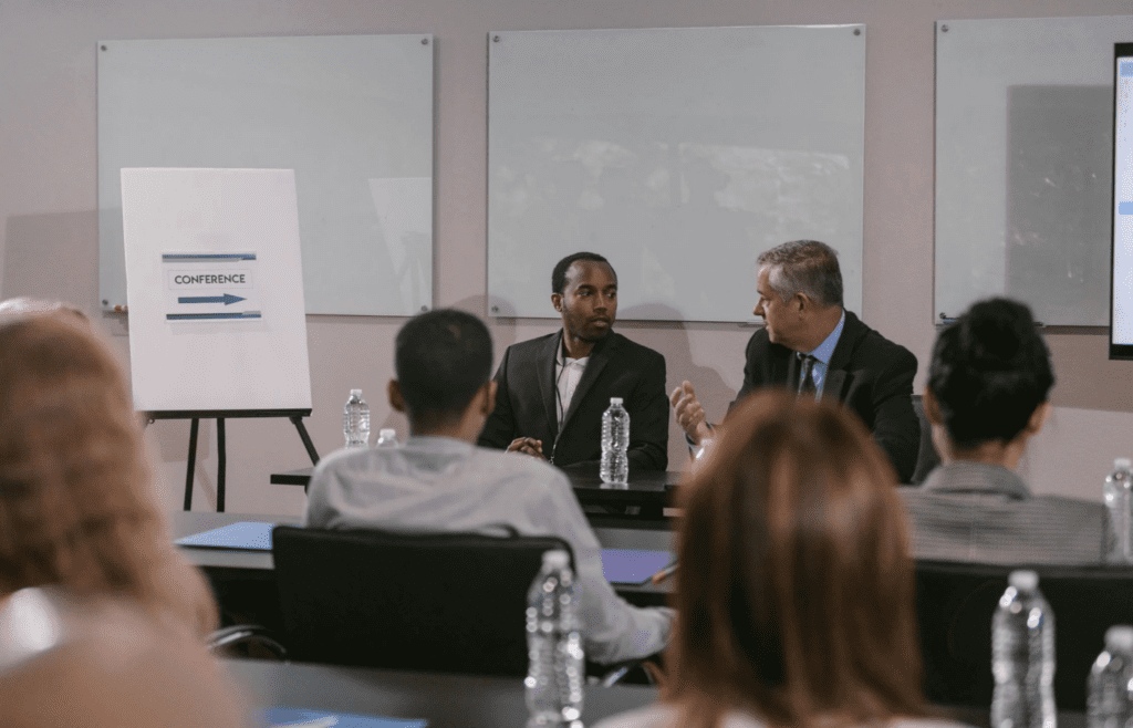 A person sitting quietly while others speak up in a meeting