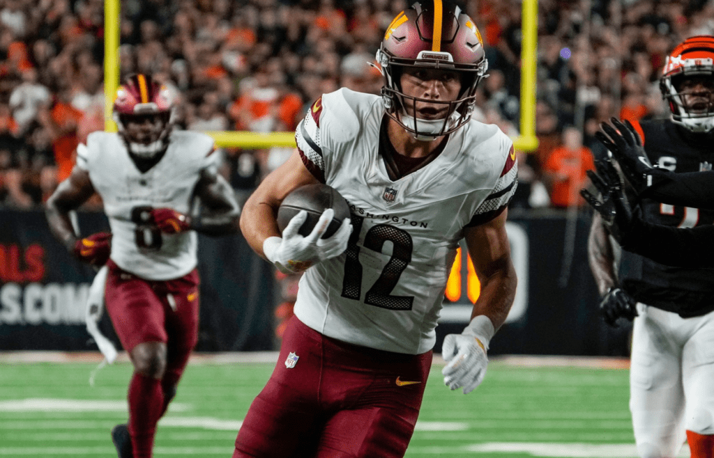 Washington Commanders wide receiver Luke McCaffrey (12) picks up yards around Cincinnati Bengals safety Geno Stone (22) Monday, September 23, 2024 at Paycor Stadium