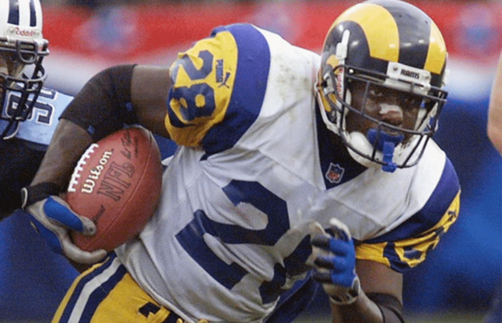 Tennessee Titans rookie and defensive end Jevon Kearse (90) chases down St. Louis Rams back Marshall Faulk (28) during action at Adelpha Coliseum in Nashville on October. 31, 1999.