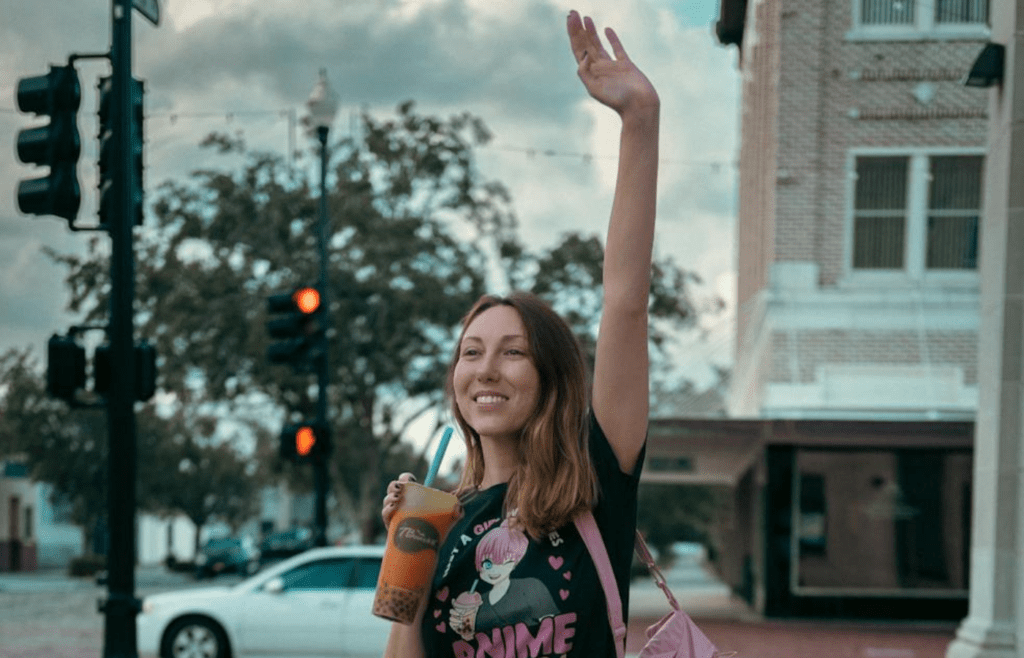 A person waving while walking away