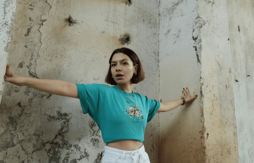 A person in vintage clothes doing a jazz hands pose.
