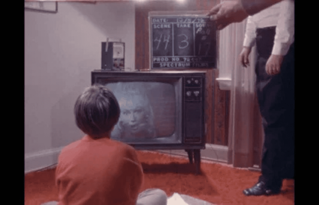 A kid sitting in front of an old tube TV