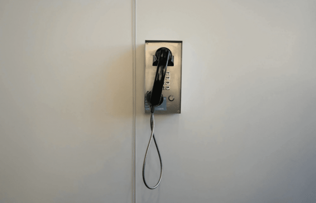 A rotary or corded phone mounted on a wall