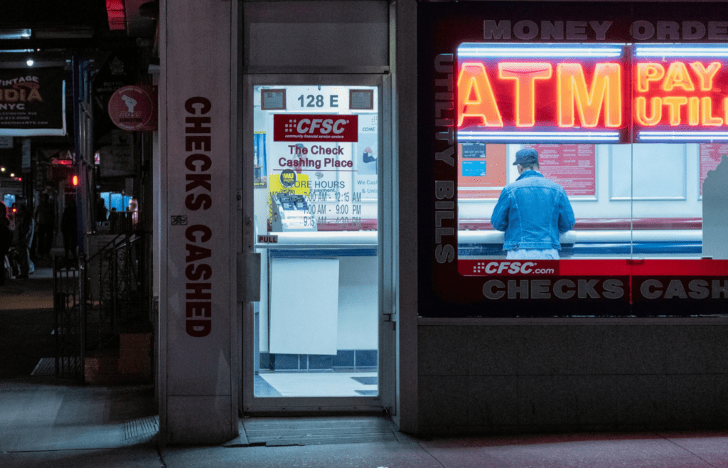 A person withdrawing cash from a convenience store ATM