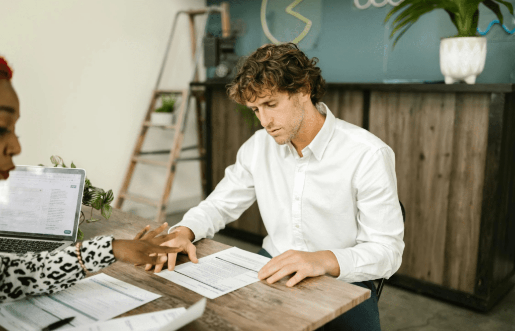 Man analyzing bank charges with advisor nearby