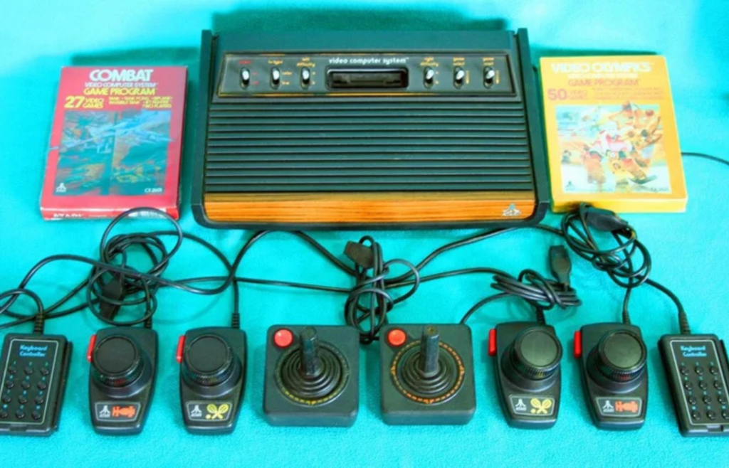 An Atari console with joystick and a row of cartridges
