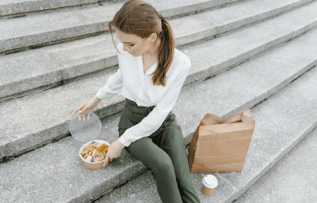 Woman with packed lunch and takeaway coffee
