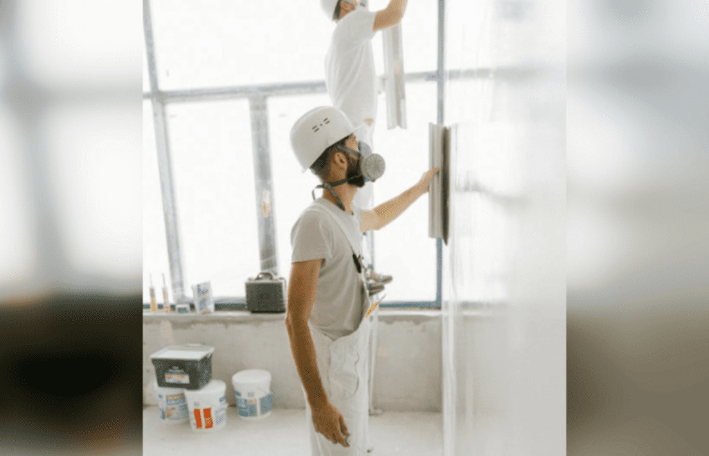 A Construction Workers Working on the Wall of a House