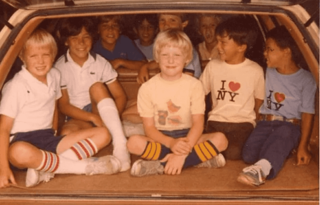 Kids sitting in the back of a station wagon without seat belts