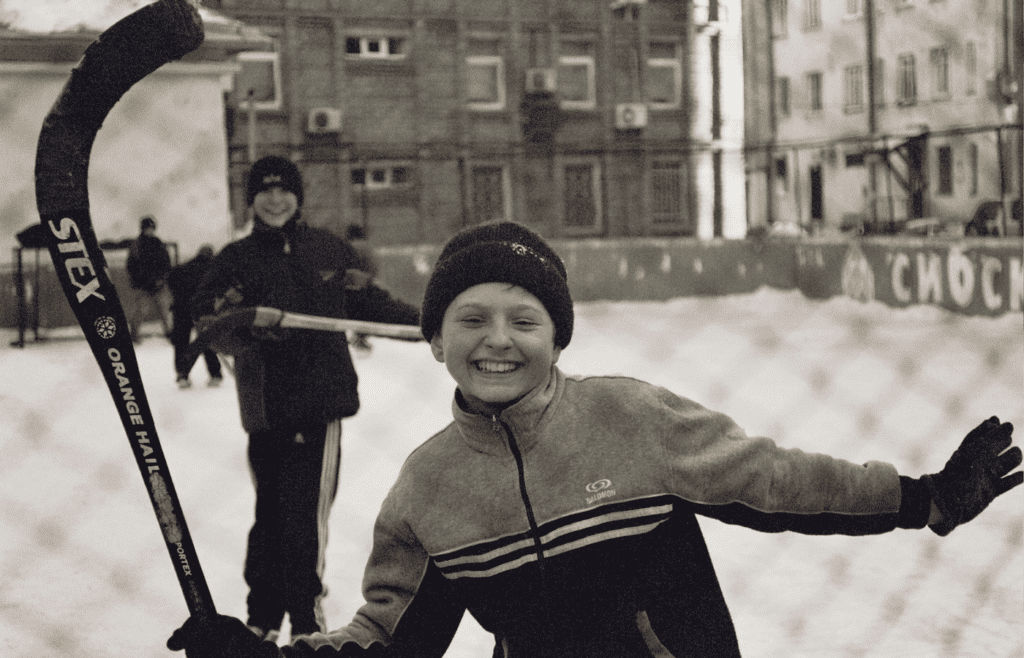 Kids playing street hockey or tag at dusk