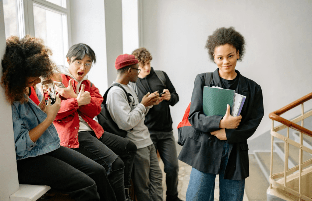 A group of teens laughing in a hallway