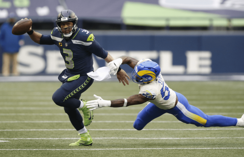 Jan 9, 2021; Seattle, Washington, USA; Seattle Seahawks quarterback Russell Wilson (3) avoids the tackle by Los Angeles Rams linebacker Leonard Floyd (54) during the third quarter at Lumen Field. Mandatory Credit: Joe Nicholson-Imagn Images