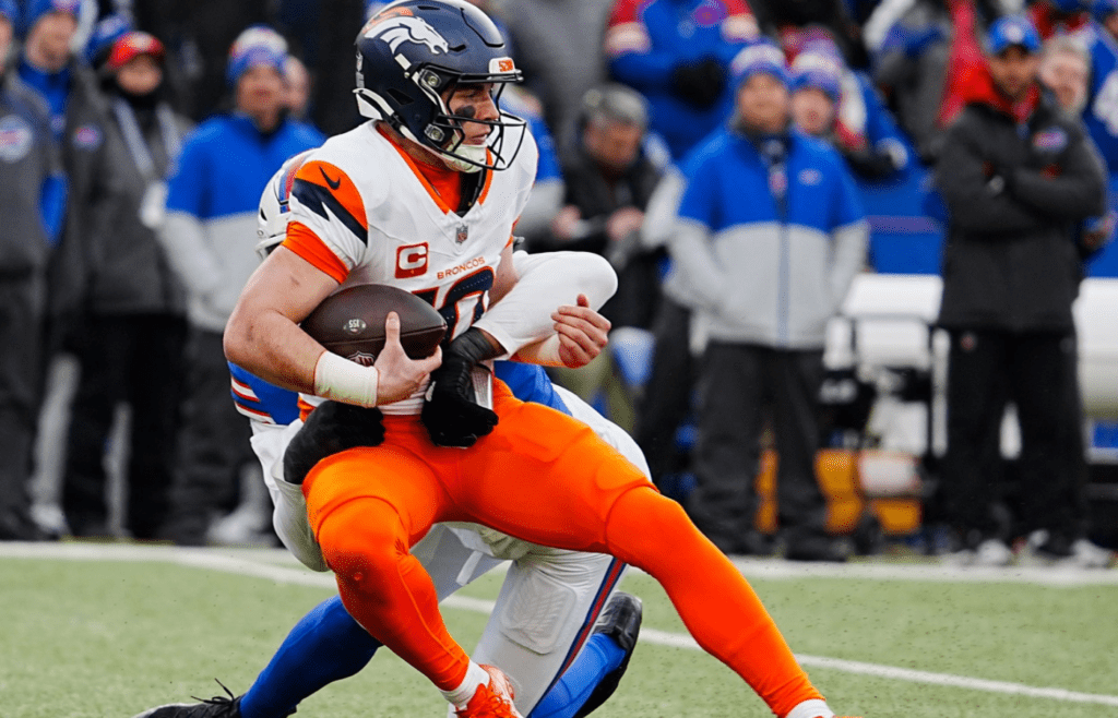Denver Broncos quarterback Bo Nix (10) gets sacked by Buffalo Bills defensive end Greg Rousseau (50) during the second half of the Buffalo Bills wild card game against the Denver Broncos at Highmark Stadium in Orchard Park on Jan. 12, 2025.