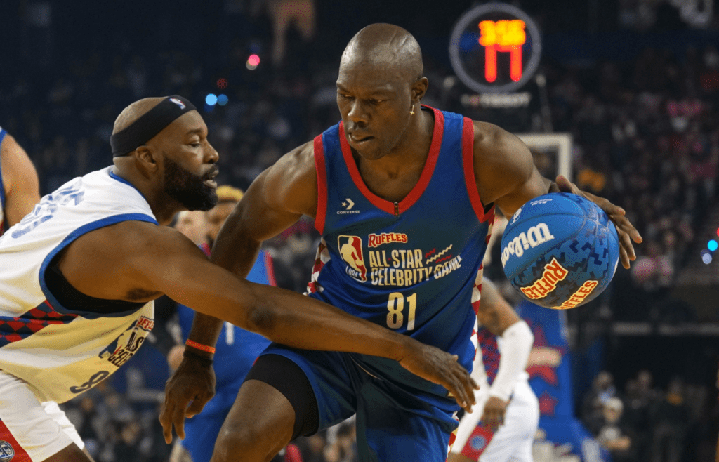 Feb 14, 2025; Oakland, California, USA; Terrell Owens (81) of Team Rice dribbles against Baron Davis (left) of Team Bonds during the celebrity game ahead of the 2025 NBA All Star Game at Oakland Arena. Mandatory Credit: Darren Yamashita-Imagn Images