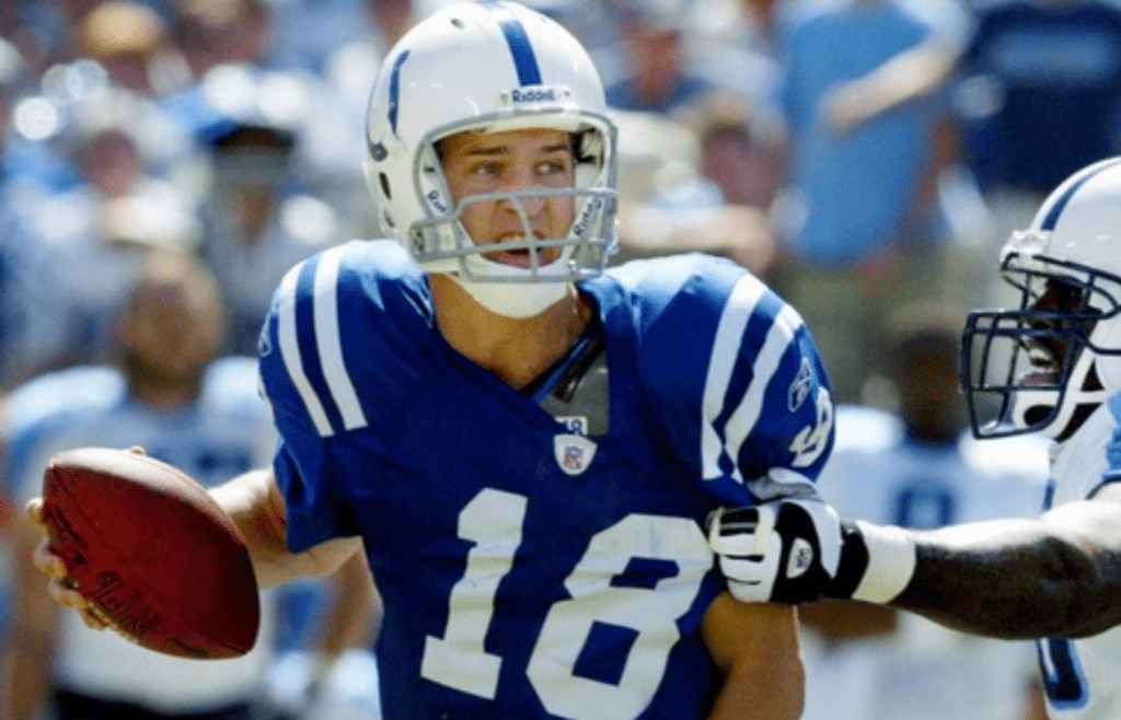Indianapolis Colts quarterback Peyton Manning (18) attempts to break free from Tennessee Titans defensive end Antwan Odom (98) at the Adelphia Coliseum in Nashville on Sept. 19, 2004. The Titans lost 31-17 in their home opener.
