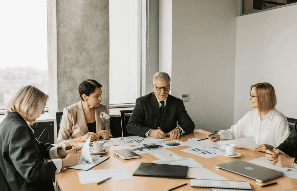 A person talking over others at a meeting table