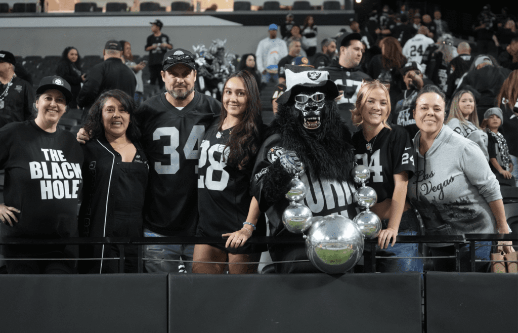Jan 5, 2025; Paradise, Nevada, USA; Las Vegas Raiders fans (from left) Marilyn Acasio aka Jungle Jane, Maria Lopez, Geoff Skarr, Alyssa Skarr, Mark Acasio aka Gorilla Rilla, Amber Mielke and Monica Martinez pose during the game against the Los Angeles Chargers at Allegiant Stadium. Mandatory Credit: Kirby Lee-Imagn Images