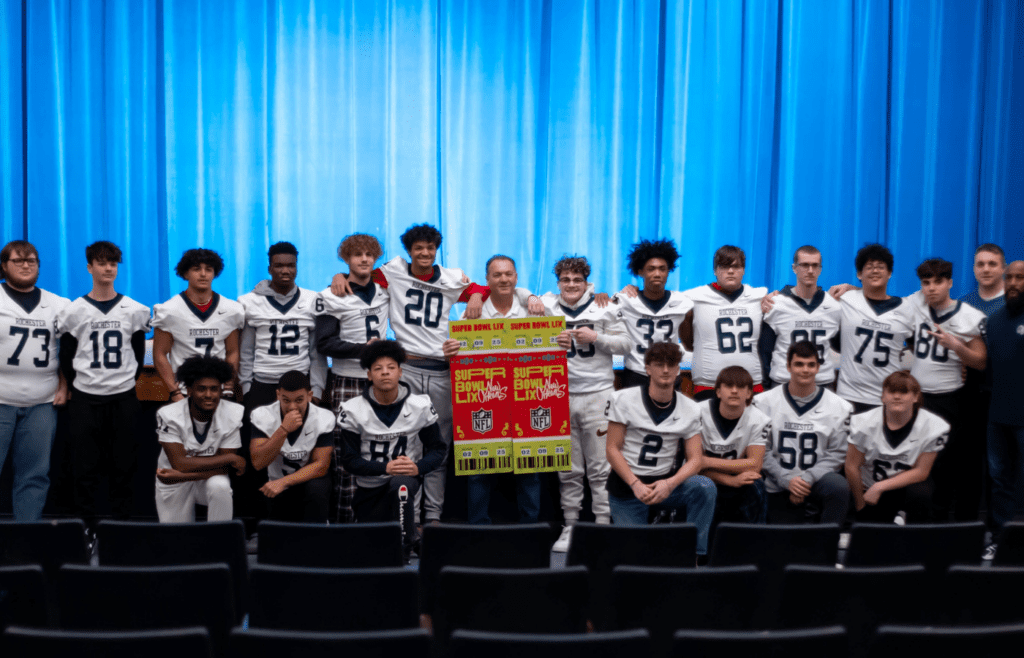 Former longtime Rochester head coach Gene Matsook takes a photo with members of his 2024 Rams football team after being gifted Super Bowl LIX tickets by the Pittsburgh Steelers on Jan. 16, 2025 at Rochester Area High School in Rochester, Pa.