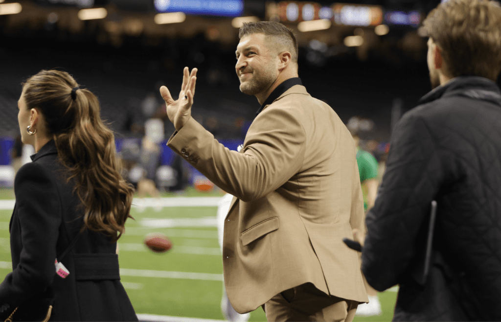 Jan 2, 2025; New Orleans, LA, USA; Tim Tebow (center) waves to fans in the stands prior to the game between the Notre Dame Fighting Irish and the Georgia Bulldogs at Caesars Superdome. Mandatory Credit: Amber Searls-Imagn Images
