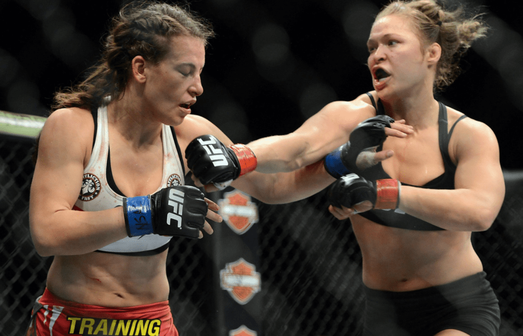 Dec 28, 2013; Las Vegas, NV, USA; Ronda Rousey (red gloves) and Miesha Tate (blue gloves) fight during their UFC women's bantamweight championship bout at the MGM Grand Garden Arena. Mandatory Credit: Jayne Kamin-Oncea-Imagn Images