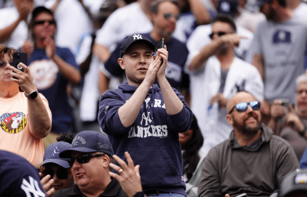 May 24, 2025; Denver, Colorado, USA; New York Yankees fans celebrate a solo home run by right fielder Aaron Judge (99) (not pictured) in the first inning against the Colorado Rockies at Coors Field. Mandatory Credit: Ron Chenoy-Imagn Images