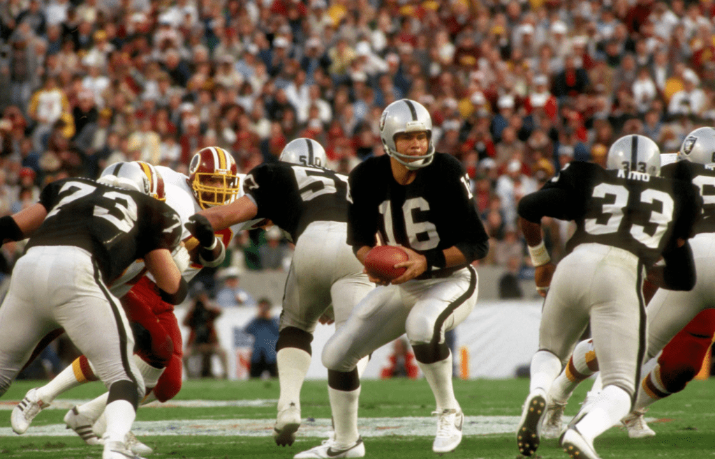 Jan 22, 1984; Tampa, FL, USA; FILE PHOTO; Los Angeles Raiders quarterback Jim Plunkett (16) in action against the Washington Redskins during Super Bowl XVIII at Tampa Stadium. The Raiders defeated the Redskins 38-9. Mandatory Credit: Tony Tomsic-Imagn Images