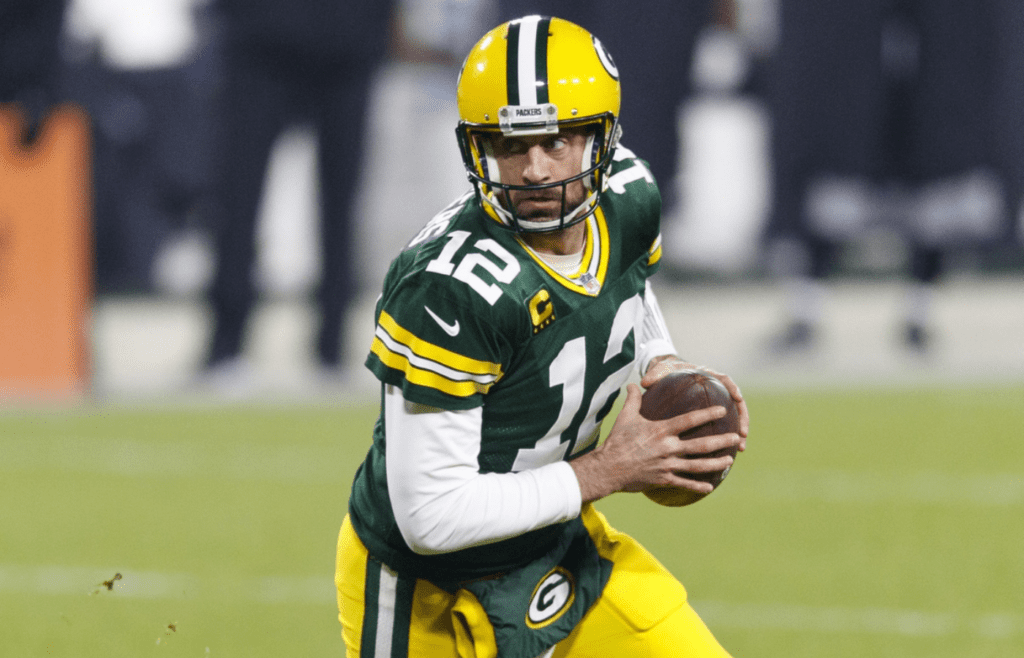 Dec 19, 2020; Green Bay, Wisconsin, USA; Green Bay Packers quarterback Aaron Rodgers (12) rolls out of the pocket during the second quarter against the Carolina Panthers at Lambeau Field. Mandatory Credit: Jeff Hanisch-Imagn Images