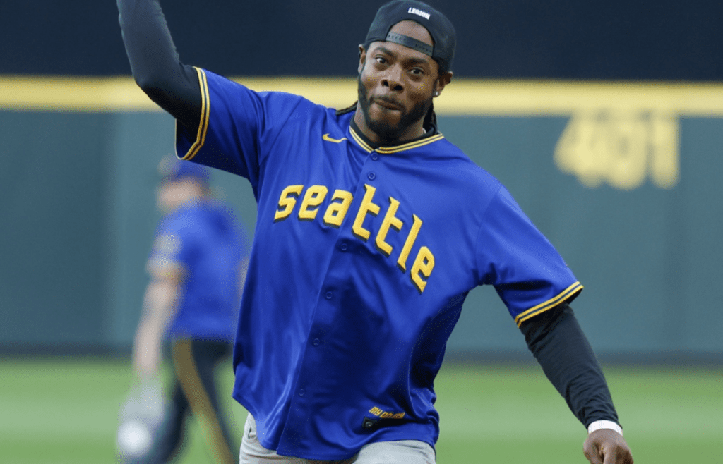 Aug 25, 2023; Seattle, Washington, USA; Seattle Seahawks former cornerback Richard Sherman throws out the first pitch before a game between the Kansas City Royals and Seattle Mariners at T-Mobile Park. Mandatory Credit: Joe Nicholson-Imagn Images