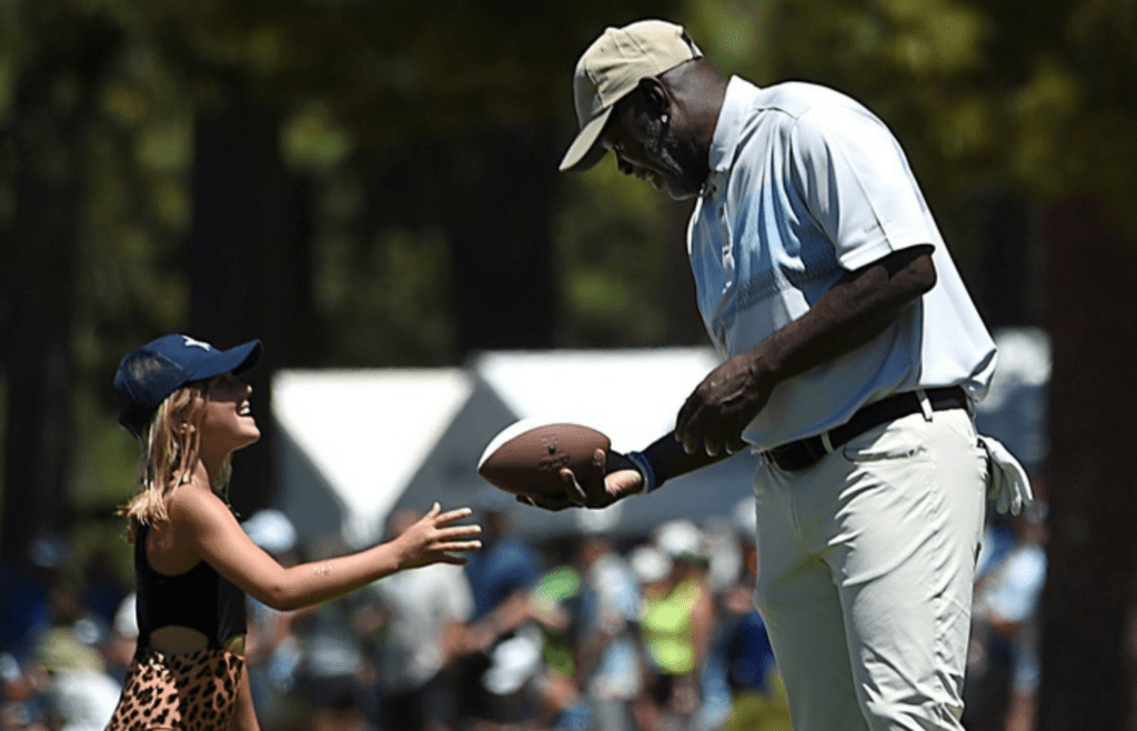 NFL Hall of Fame member Emmitt Smith signs a football for a young Dallas Cowboys fan during the American Century Championship golf tournament at the Edgewood Tahoe Golf Course in Stateline on July 14, 2023