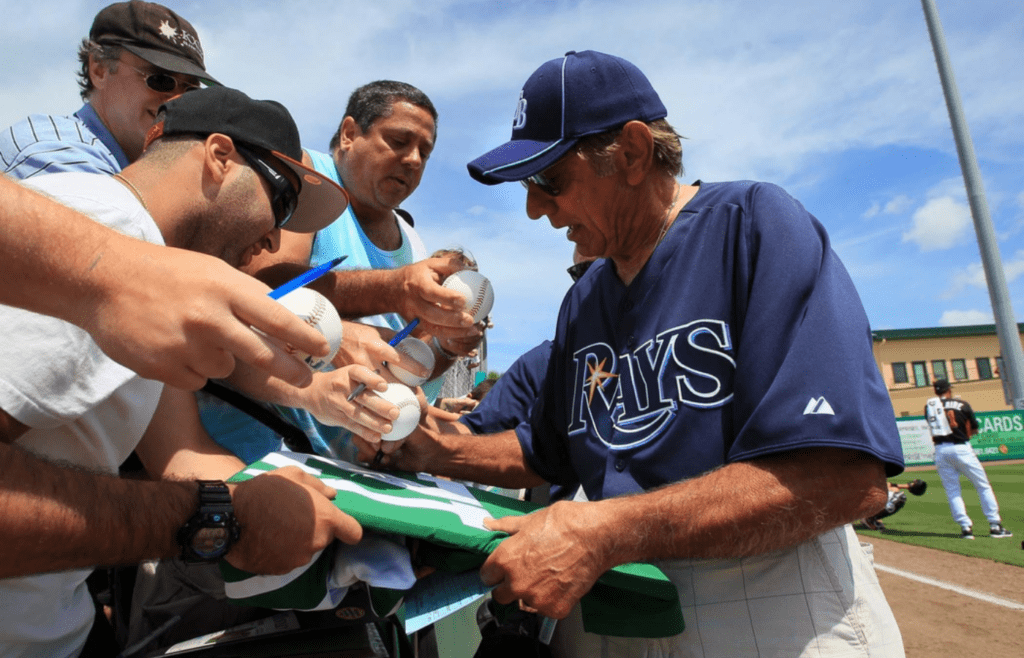 Joe Namath signs autographs at the Rays/Marlins game at Roger Dean Stadium. Rays manager Joe Maddon wore white shoes today in honor of Namath, who played in low-cut white shoes during his NFL career. Namath lives close to Roger Dean Stadium in Tequesta. \"I just like Joe's style and what I've read about him,\" Namath said. \"I was flattered that he invited me to practice.