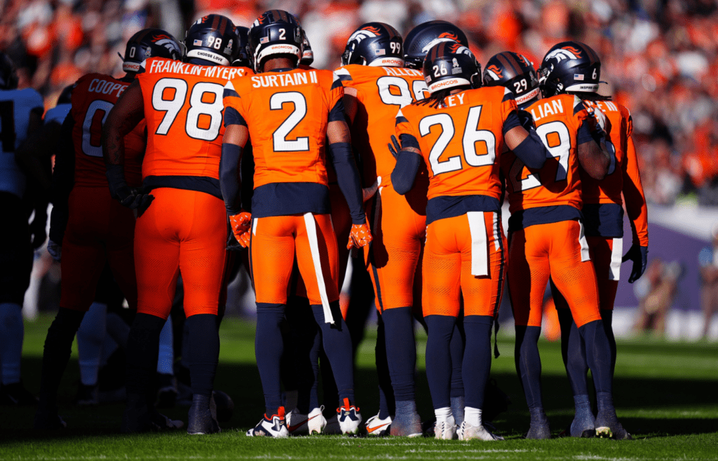 Members of the Denver Broncos defensive team huddle in the first quarter at Empower Field at Mile High.