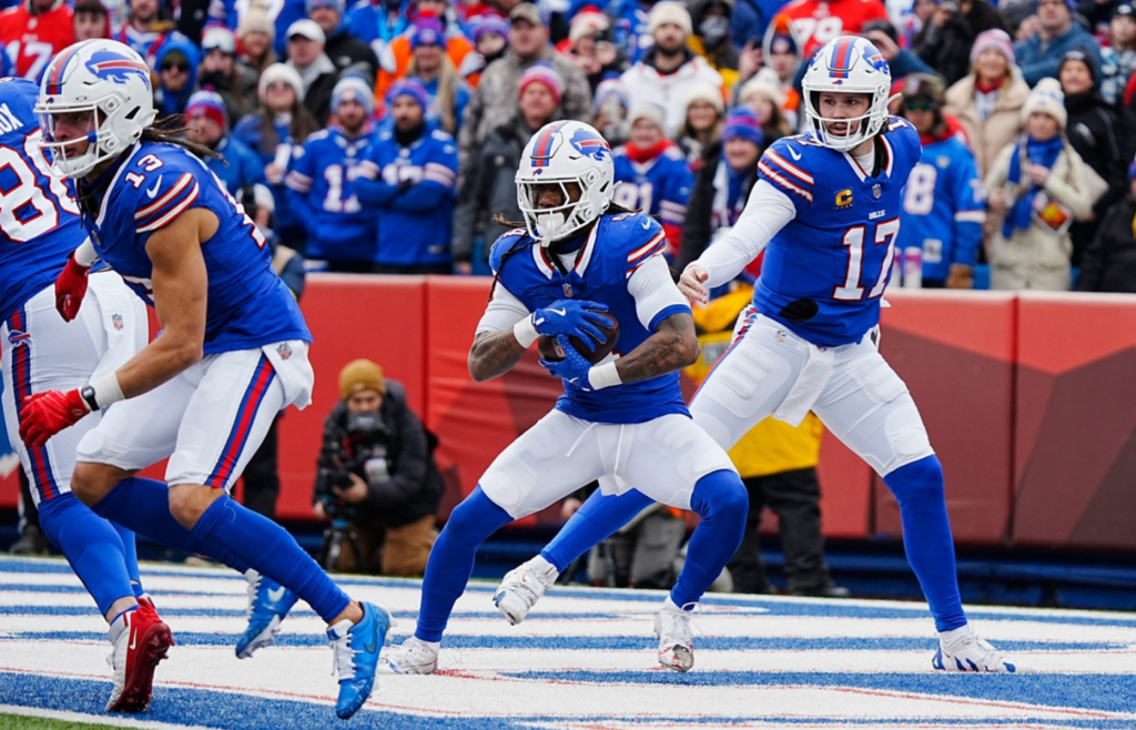Buffalo Bills quarterback Josh Allen hands the ball off to Buffalo Bills running back James Cook during the first half of the Buffalo Bills wild card game against the Denver Broncos at Highmark Stadium in Orchard Park on Jan. 12, 2025. The punt return and a team foul put the team on the goal line. Cook ran it out for a first down