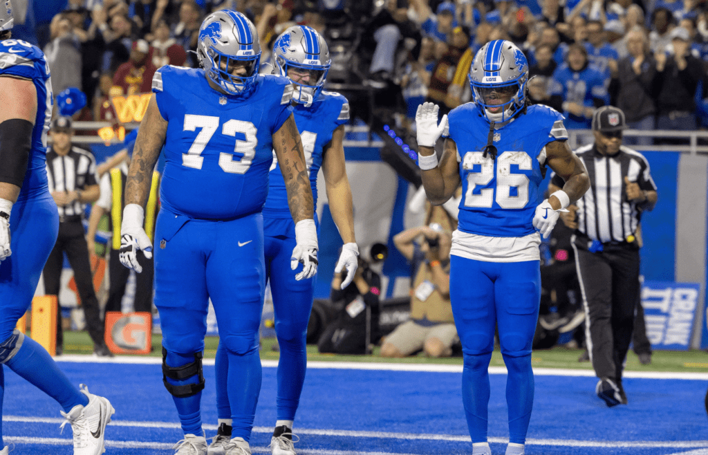 Jan 18, 2025; Detroit, Michigan, USA; Detroit Lions running back Jahmyr Gibbs (26) celebrates a touchdown with team mates during the first quarter against the Washington Commanders at Ford Field. Mandatory Credit: David Reginek-Imagn Images