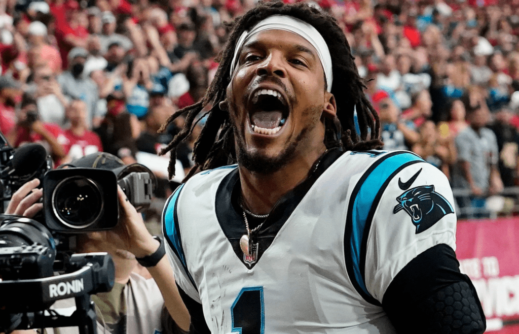 Carolina Panthers quarterback Cam Newton yells \"I'm back!\" after scoring a rushing touchdown against the Arizona Cardinals in a game in 2021